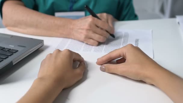 Practitioner marking points in insurance and giving it to patient, healthcare — Stock Video