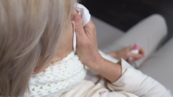 Mujer anciana enferma estornudando en el tejido usando aerosol nasal, problema de alergia estacional — Vídeo de stock