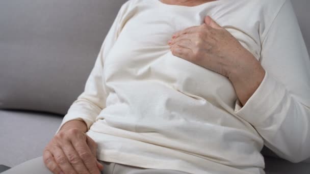 Mulher idosa de mãos dadas no peito, chamando ambulância, primeiros socorros, cuidados de saúde — Vídeo de Stock