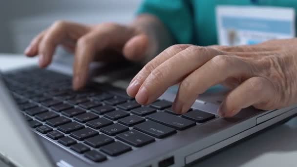 Close-up de mãos de enfermeira digitando no laptop, preenchendo dados no prontuário online — Vídeo de Stock