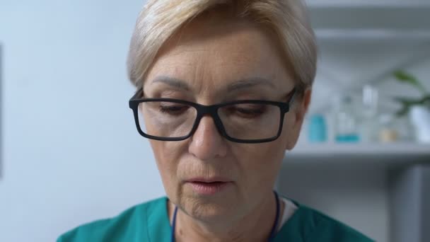 Reife weibliche Therapeutin sucht Patientin medizinische Form in Dokumenten, Krankenhaus — Stockvideo