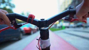 Kadın elleri bisiklet direksiyonu tutuyor, şehir sokaklarında geziyor, boş zaman aktiviteleri, yakın çekim.