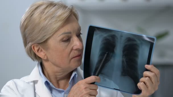 Női onkológus mutatja tüdő röntgen és rázófej, terminális rák szakaszban — Stock videók