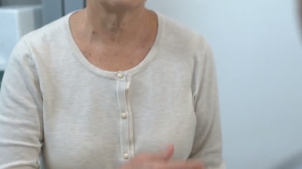 Пожилая женщина держит руку на груди, осмотр здоровья, прием у врача — стоковое видео