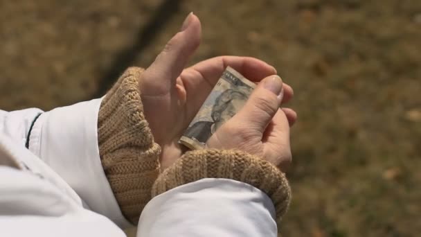 Oudere vrouw houdt dollar hand, pensioen armoede, sociale onzekerheid, begroting — Stockvideo