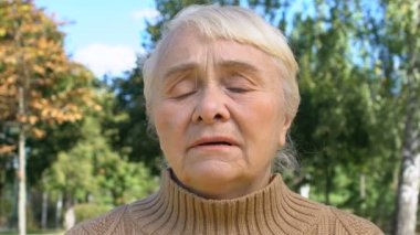 Üzgün görünen yaşlı bayan üzgün görünüyor, pişmanlık ifadesi, hayal kırıklığı