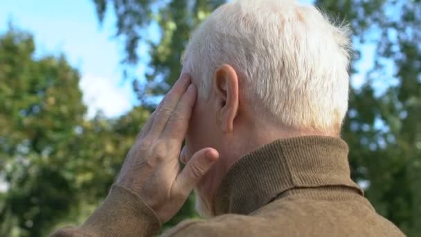Старый мужчина страдает головной болью, проблемы со здоровьем в возрасте, неврологические заболевания, медицина — стоковое видео