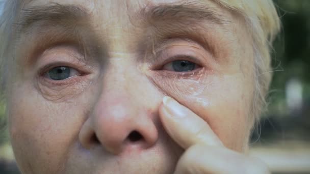Плачущая пенсионерка, вытирающая слезы, старое нуждающееся поколение, социальная незащищенность — стоковое видео