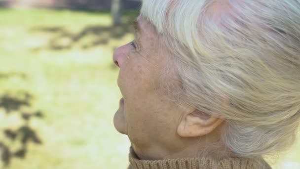 Depressed retired woman wiping tears outdoors, loss hopelessness, feeling lonely — Stock Video
