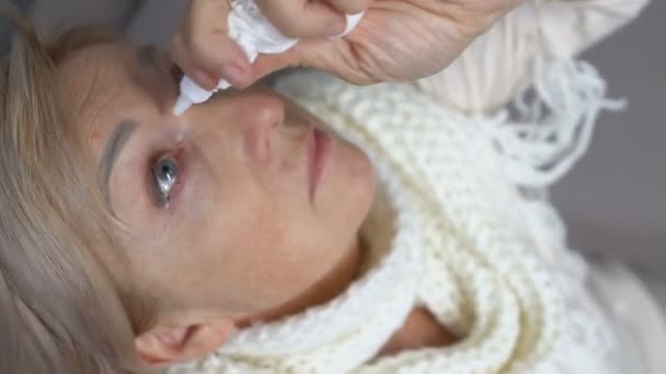 Old woman in scarf using eye drop from dryness, health support, pharmacy — Stock Video