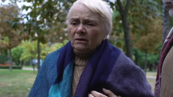 Пожилая женщина прикасается к груди, ощущая внезапную боль в сердце, риск инсульта — стоковое видео