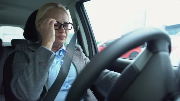 Åldrad affärskvinna känner stark migrän, sitter på förarsätet, hälsovård — Stockvideo