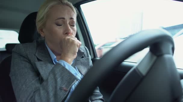 Mujer madura enferma tosiendo en la palma sentada en el asiento del coche de los conductores, enfermedad estacional — Vídeo de stock