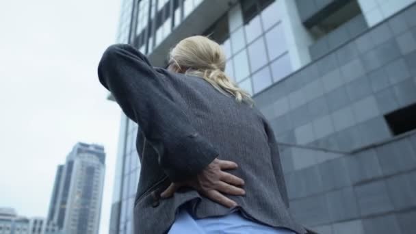 Vrouw die rugpijn voelt, die de trap oploopt, wervelontsteking, achteruitkijkspiegel — Stockvideo