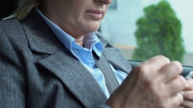 Yorgun iş kadını baş ağrısı çekiyor. Otomobilde ağrı kesici alıyor.