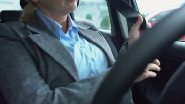 Takım elbiseli bayan yönetici emniyet kemeri takıyor, sürüş için hazırlanıyor, trafik kuralları