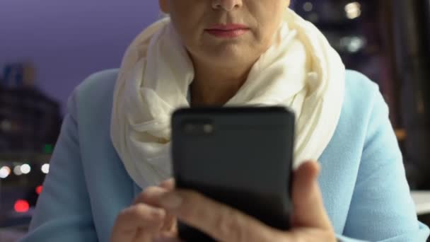 Серьёзная пожилая женщина разговаривает на улице со смартфоном, решает рабочие проблемы — стоковое видео