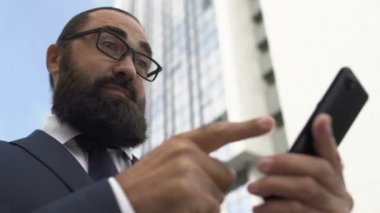 Başarılı bir iş adamı cep telefonu e-postalarını okuyarak evet sevindirici haberler veriyor.