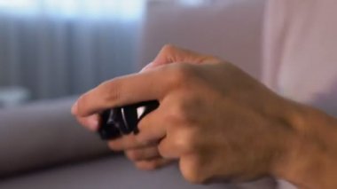 Genç bir kadın heyecanlı bir şekilde joystick tuşlarına basıyor, duygusal olarak video oyunu oynuyor.