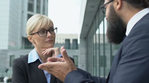 Vrouw in pak luistert naar geïnspireerde mannelijke collega, discussieert over perspectieven — Stockvideo