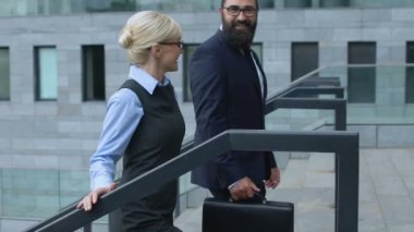 İş ortakları modern ofis merkezine yaklaşıyorlar. Yukarı çıkıp konuşuyorlar.