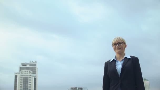 Mujer sonriente en ropa formal caminando sobre el fondo del cielo, promoción de carrera, éxito — Vídeo de stock