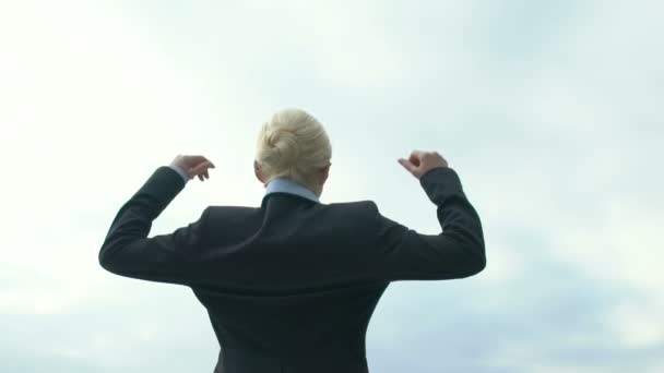 Lady i formalwear firar seger och lyfta händerna mot himlen, framgångsrik affär — Stockvideo