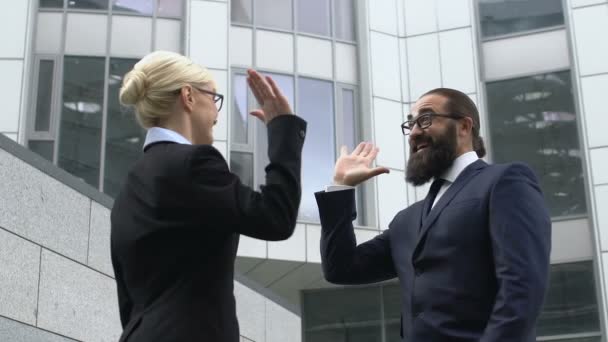 Skäggig affärsman ger high-five till kvinnlig kollega, glad över framgång — Stockvideo