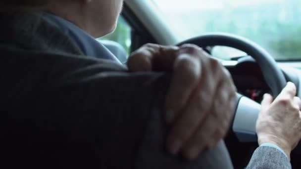 Беспокойная женщина-водитель массирует больное плечо, старый результат травмы, здоровье — стоковое видео
