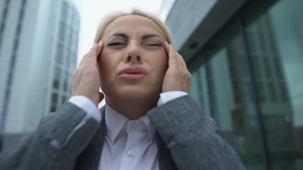 Volwassen zakenvrouw aanraken van tempels, lijden verschrikkelijke migraine, gezondheidszorg — Stockvideo