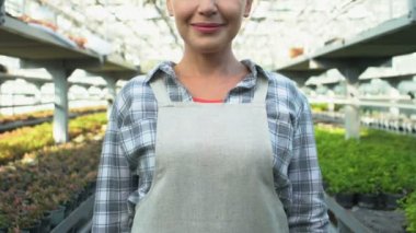 Neşeli tarım işçisi silah katlayan gülümseyen kamera, sera işi