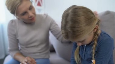 Önemseyen anne teselli ediyor ve kucaklıyor küçük üzgün kız okulunun zorbalık sorunu