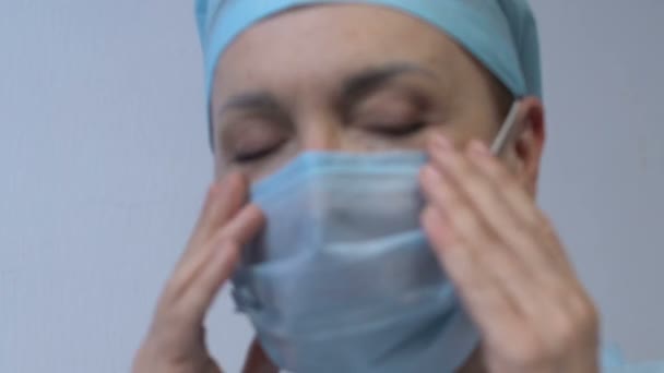 Extreem vermoeide dame doc gevoel duizeligheid afzetten masker en wrijven tempels — Stockvideo