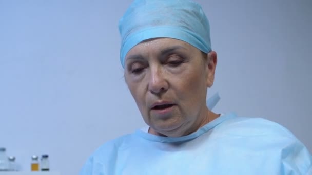 Chirurgo donna stanca togliersi maschera e guanti dopo un'operazione importante — Video Stock