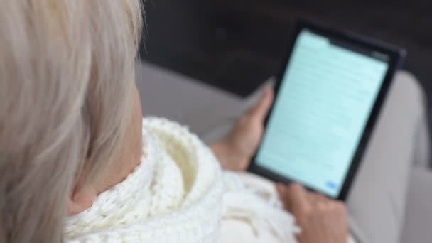 Doente sênior leitura do livro eletrônico feminino no PC tablet, epidemia sazonal — Vídeo de Stock