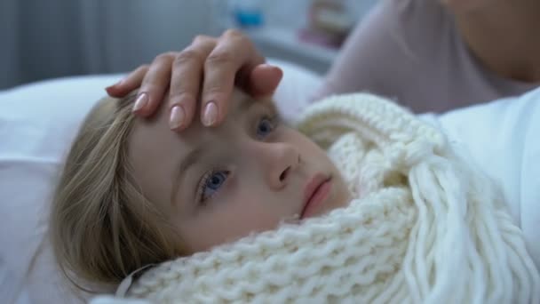 Moeder troosten weinig zwak dochter in sjaal liggend in bed, grippe en gezondheid — Stockvideo