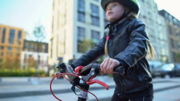 Roztomilé ženské dítě v bezpečnostní přilbě připraven k jízdě na kole venkovní, oblíbený koníček — Stock video