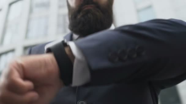 Homem rico em terno de negócios verificando o tempo ao ar livre, olhando para relógio de pulso, close-up — Vídeo de Stock