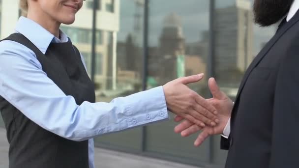 Mujer jefe estremeciendo la mano con la pareja masculina tratando de besar el brazo femenino, descontento — Vídeo de stock