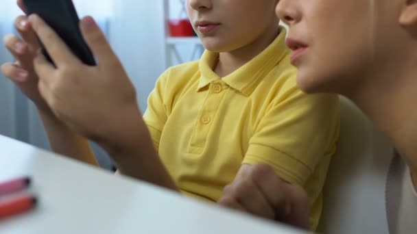 Niño mostrando aplicación moderna madre en el teléfono inteligente, logro del juego — Vídeo de stock