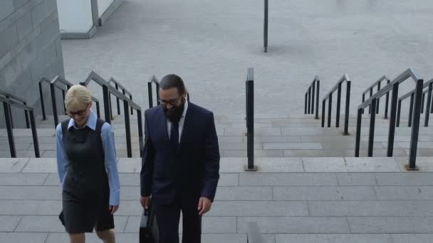 Señora y socios masculinos caminando en la escalera cerca del edificio de oficinas, cooperación — Vídeos de Stock