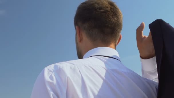 Geïnspireerd mannelijk baas zetten jas op schouder en genieten van skyscape, achteraanzicht — Stockvideo