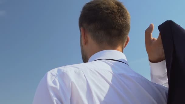 Inspired male boss putting jacket on shoulder and enjoying skyscape, back view — Stock Video