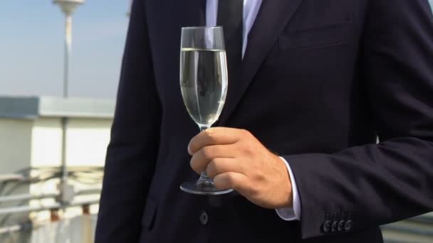 Hombre de traje de negocios sosteniendo copa de champán en la celebración de la fiesta del techo corporativo — Vídeos de Stock