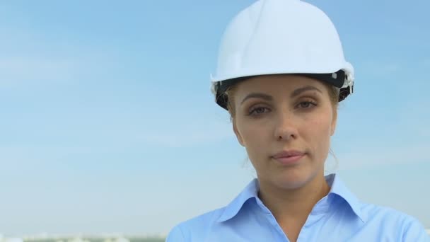Ingénieur féminine sérieuse dans le casque regardant la caméra, la profession et l'expérience — Video