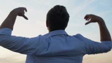 Heyecanlı adam ellerini kaldırıyor. Başarılı bir jest yapıyor, hayat kurtarıyor, geriye bakıyor.