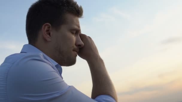 Homem triste pensando em problemas em sua vida no fundo do céu da noite — Vídeo de Stock