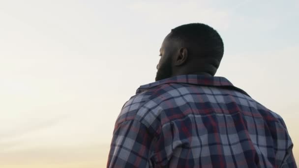Africký Američan dělá důležitá rozhodnutí v životě při pohledu na večerní obloze — Stock video