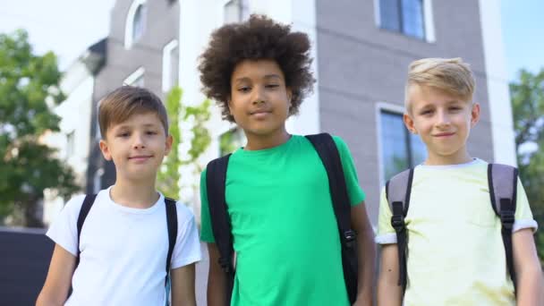 Empresa de meninos multiétnicos abraçando e olhando para a câmera, conceito de amizade — Vídeo de Stock