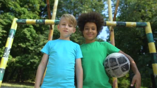 Équipes multiethniques avec le football souriant et regardant la caméra, passe-temps — Video